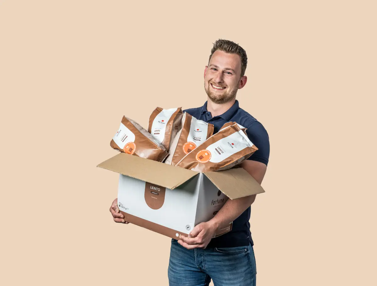 Medewerker regio Rijnmond heeft een doos met zakken met koffiebonen in z'n hand