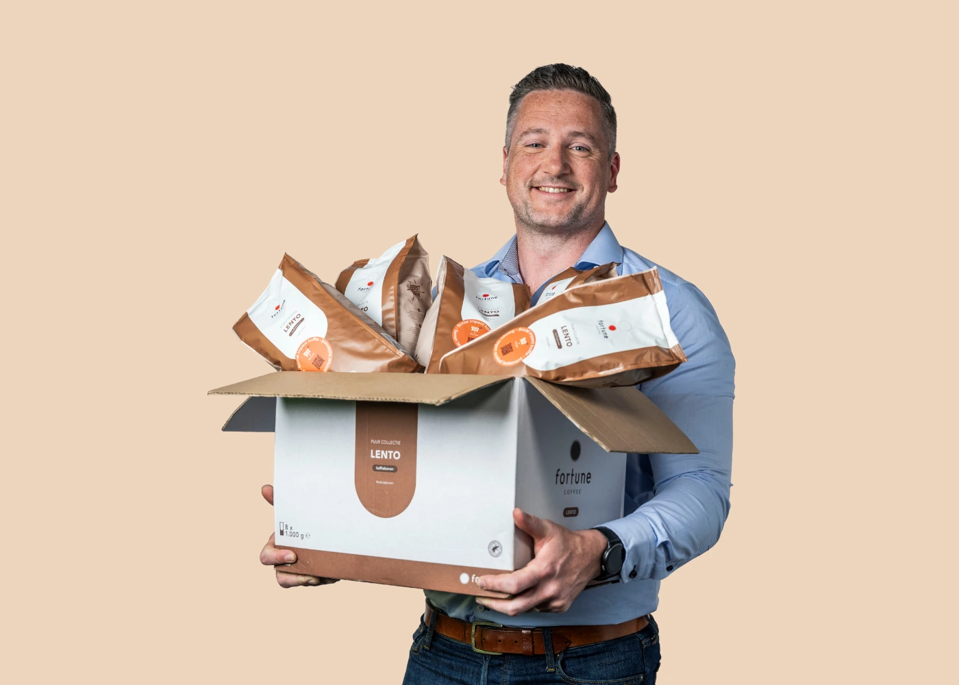 Een werknemer staat met een doos koffiezakken in zijn handen