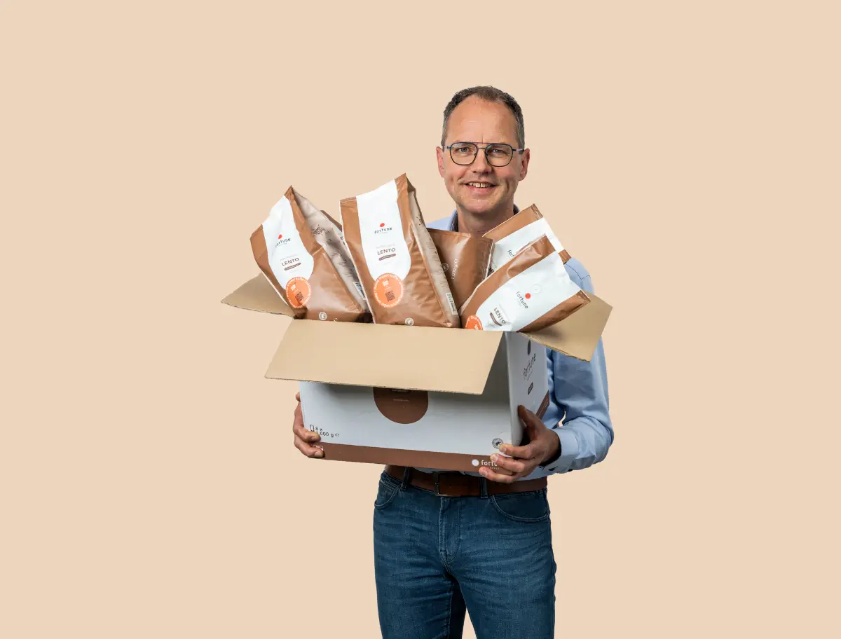 Een werknemer heeft een doos koffie in zijn handen