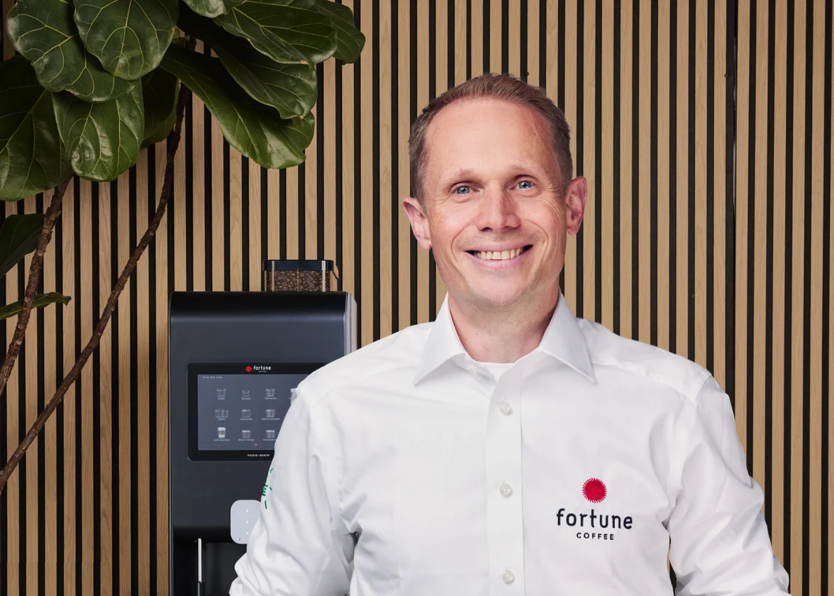 Ondernemer regio Den Bosch staat voor een koffieautomaat