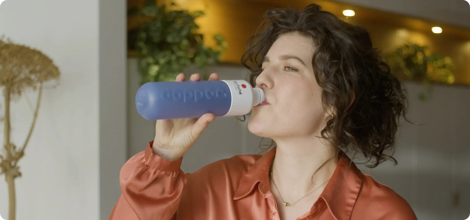 Vrouw drinkt water uit de dopper op het werk