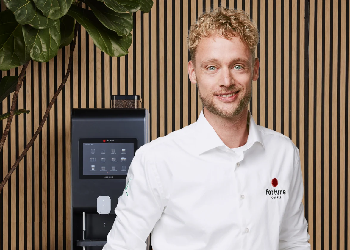 Ondernemer regio Woerden - Gouda staat voor een koffieautomaat