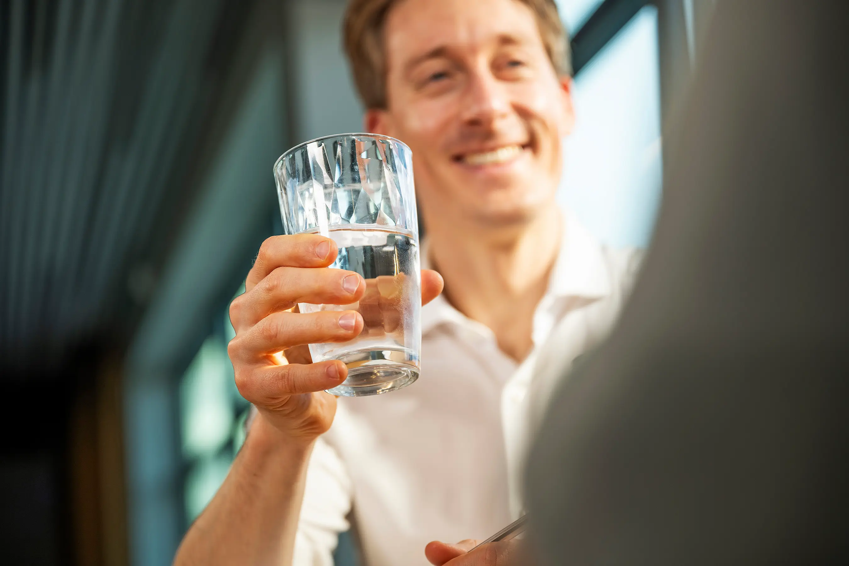 Een werknemer drinkt een glas water