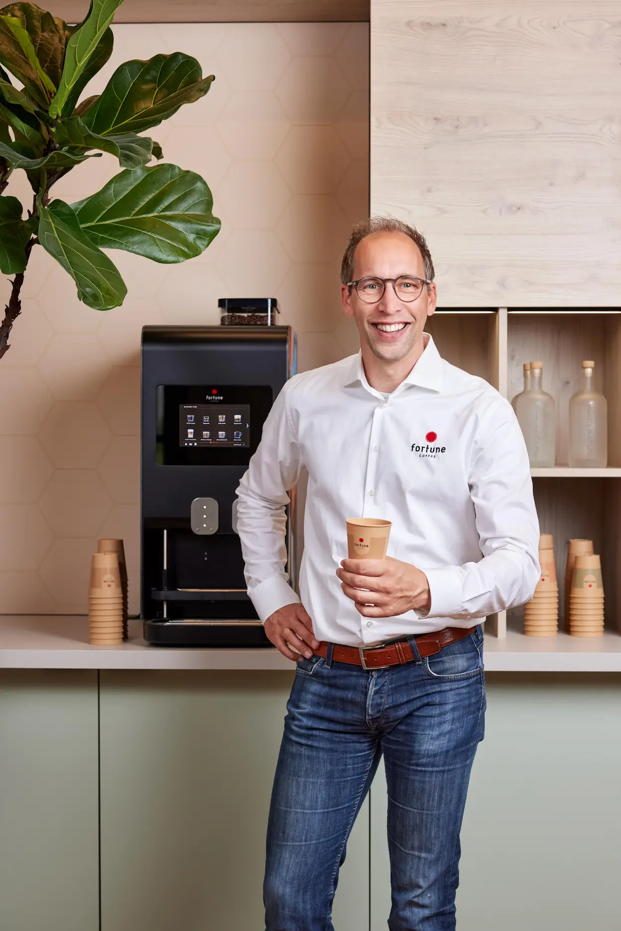 Ondernemer bij een koffieautomaat