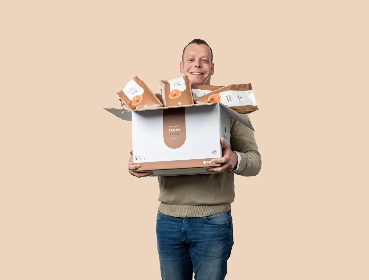 Medewerker regio Winschoten heeft een doos met zakken met koffiebonen in z'n hand